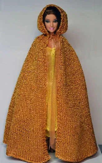 Barbie i gyllene stickad cape med kapuschong och gul klänning.