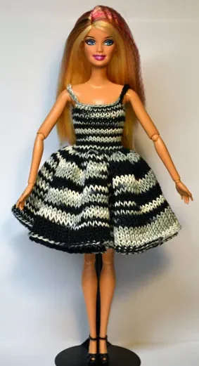 Barbie i stickad svart-vit randig klänning med volanger.