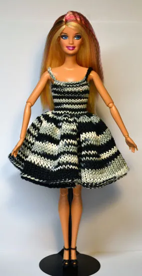 Barbie i stickad svart-vit randig klänning med volanger.