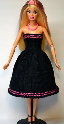 Barbie i svart stickad klänning med cerise-rosa ränder.