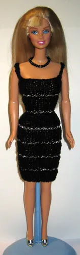 Barbie i svart stickad klänning med guldränder.