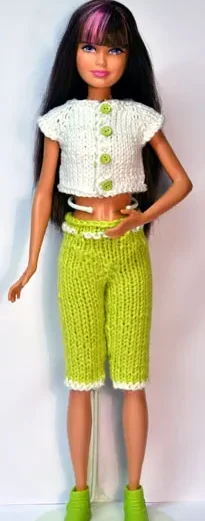 Skipper i vit stickad topp med gröna knappar och gröna shorts.