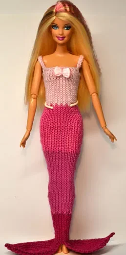 Barbie i stickad rosa sjöjungfruklänning med ljusrosa överdel och mörkrosa fena.