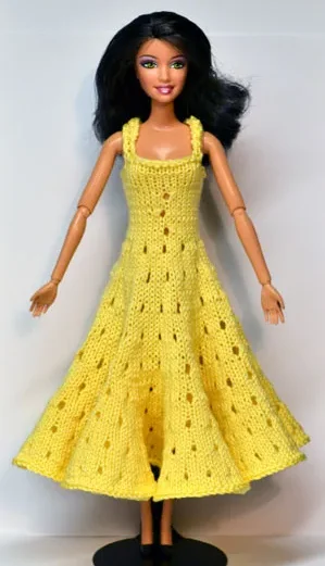 Barbie i gul stickad klänning med hålmönster.