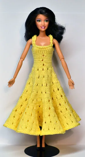 Barbie i gul stickad klänning med hålmönster.