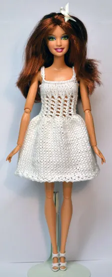 Barbie i stickad vit klänning med hålmönster.