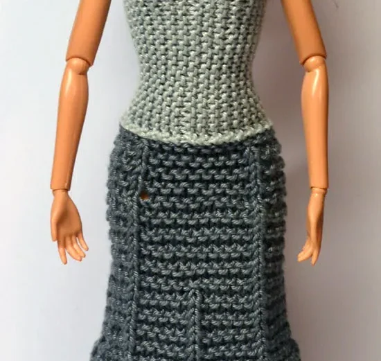 Barbie i stickad grå klänning med ljusgrå linne och mörkgrå kjol.