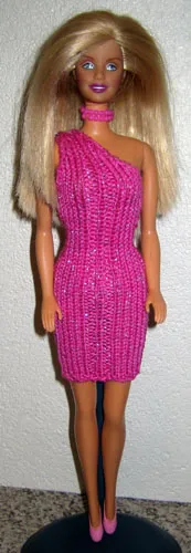 Barbie i cerise-rosa stickad klänning med one-shoulder design och silvertråd.
