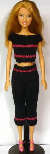 Barbie i stickad svart topp och byxor med vinröda ränder.