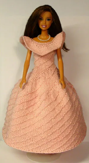 Barbie i stickad rosa klänning med snedrutmönster och vid kjol.
