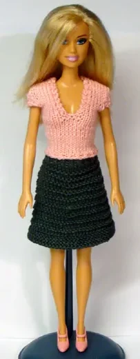 Barbie i rosa stickad topp och grön kjol.