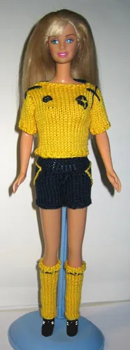 Barbie i gul fotbollströja med blå shorts och gula strumpor.