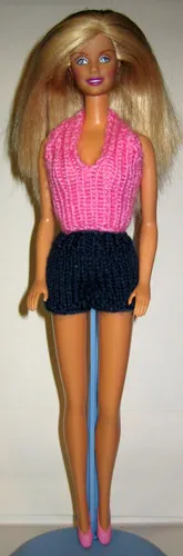 Barbie i rosa stickad topp och mörkblå shorts.
