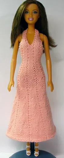 Barbie i rosa stickad klänning med hålmönster.