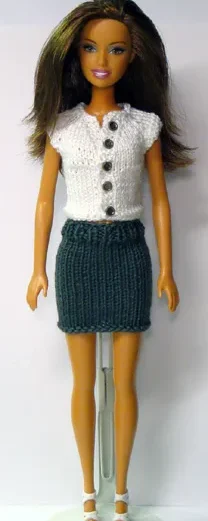 Barbie i vit stickad topp med knappar och grön kjol.