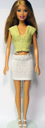 Barbie i ljusgrön stickad topp med V-ringning och vit kjol.