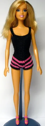 Barbie i svart stickad baddräkt med cerise ränder.