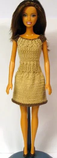 Barbie i beige stickad klänning med brun kant.