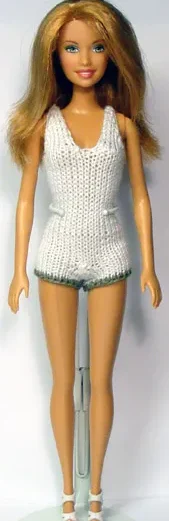 Barbie i vit stickad dress med gröna kanter nertill.