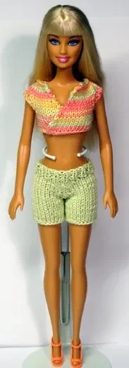 Barbie i rosa omlott-topp och gröna stickade shorts.
