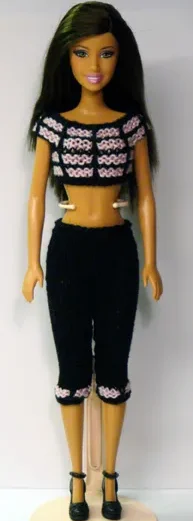 Barbie i svart stickad topp och tights med rosa mönster.