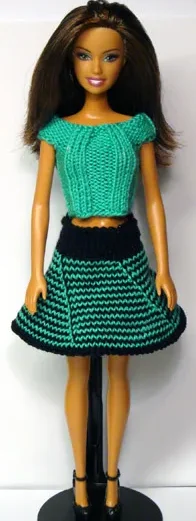 Barbie i grön stickad topp med flätat mönster och svart-grön randig kjol.