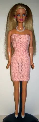 Barbie i rosa stickad tubklänning med hålmönster.