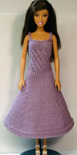 Barbie i lila stickad klänning med strukturmönster.