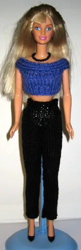 Barbie i blå stickad topp och svarta byxor.