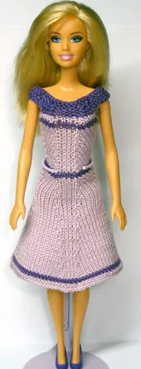 Barbie i stickad lila och rosa klänning med hålmönster.