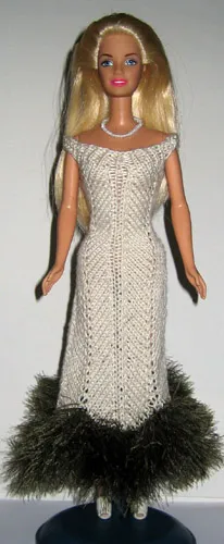 Barbie i beige stickad klänning med grön luddkant.
