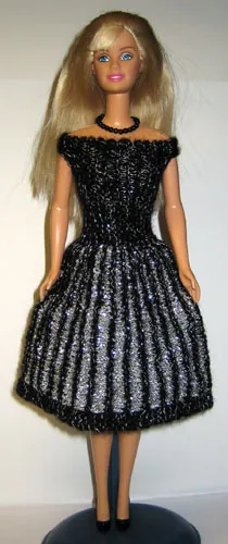 Barbie i stickad svart och silver klänning med randmönster.