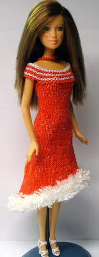 Barbie i röd stickad klänning med vit luddkant och glitterdetaljer.