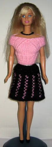 Barbie i rosa stickad topp och svart kjol med rosa detaljer.