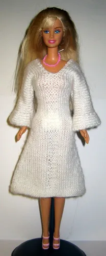 Barbie i vit stickad klänning med långa utställda ärmar