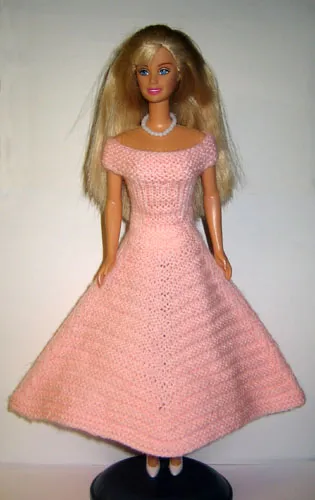 Barbie i stickad rosa vid klänning med off-shoulder design.