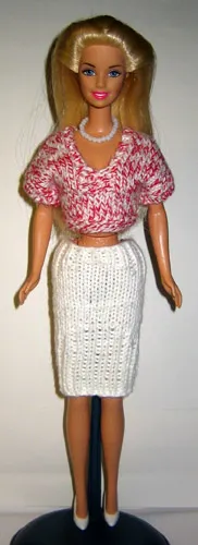 Barbie i melerad rosa topp och vit stickad kjol.