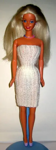 Barbie i vit stickad klänning med resårmönster.