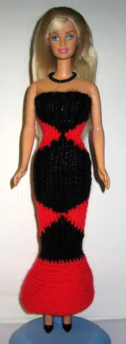 Barbie i stickad svart och röd långklänning med diamantmönster.