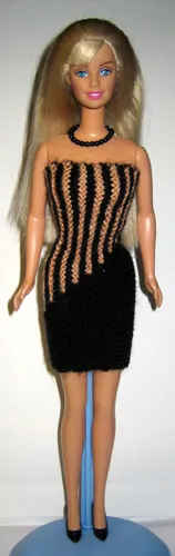 Barbie i svart och orange rätstickad klänning med randmönster.