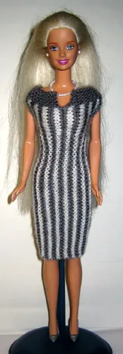 Barbie i grå och vit randad stickad klänning.