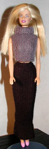 Barbie i grå stickad topp och lång svart kjol.