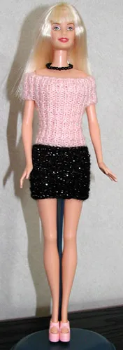 Barbie i rosa stickad topp och svart kjol med glittertråd.