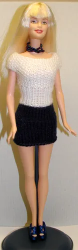 Barbie i vit och blå stickad klänning med mosstickningsmönster.