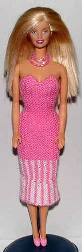 Barbie i rosa stickad klänning med vita detaljer.