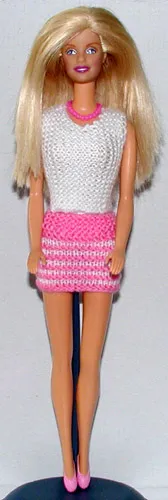 Barbie i vit och rosa stickad outfit med hålmönster.