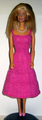 Barbie i rosa stickad klänning med hålmönster.