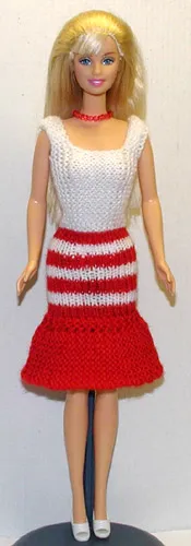 Barbie i stickad vit och röd klänning med randiga detaljer.