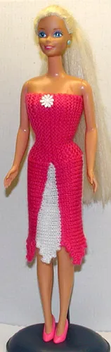 Barbie i cerise stickad klänning med vit panel på framsidan.