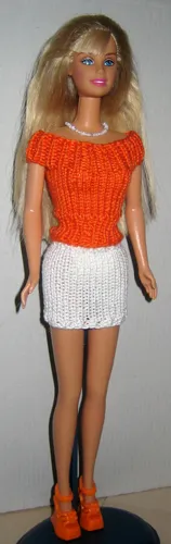 Barbie i orange stickad topp och vit minikjol.